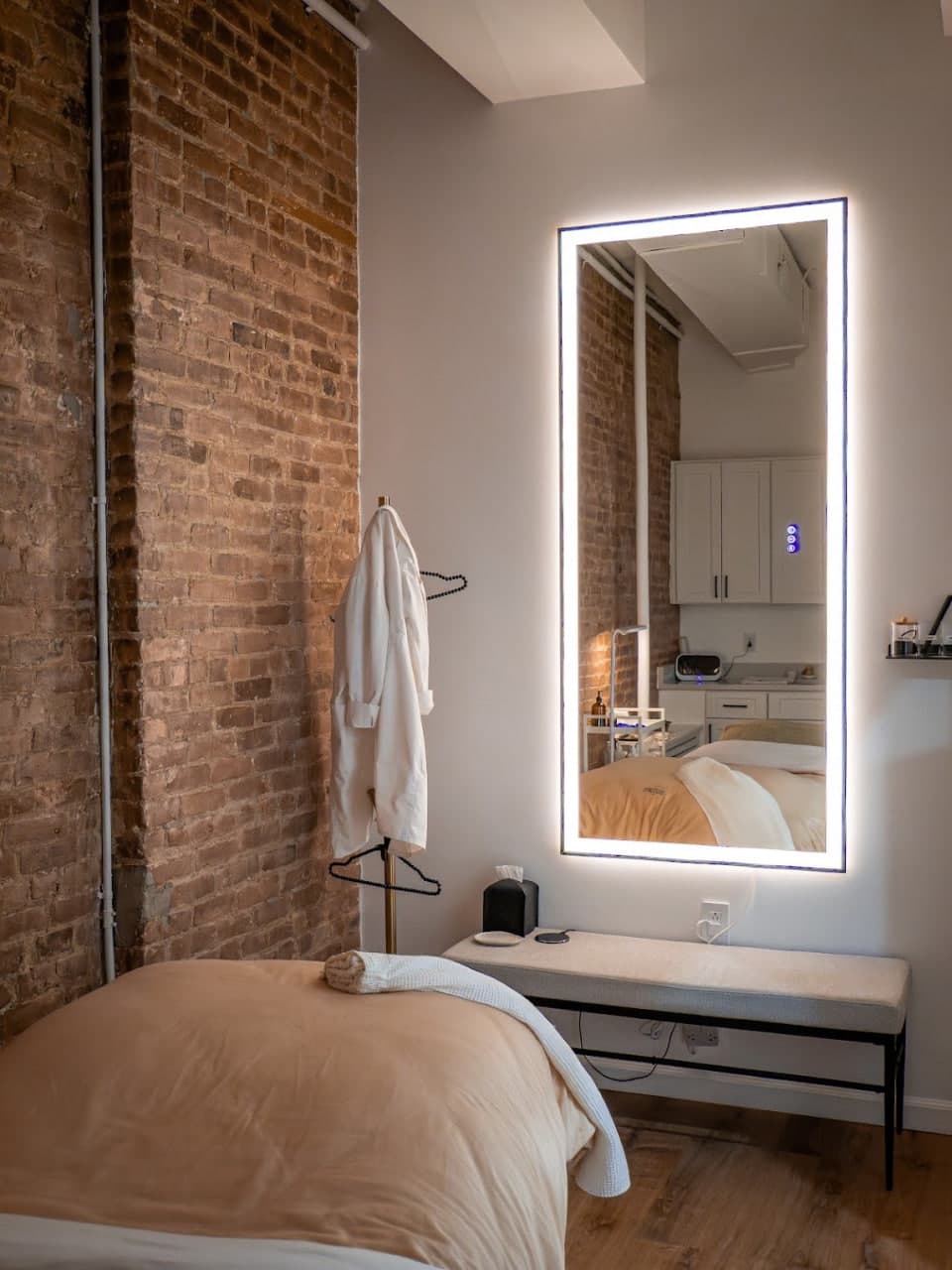 Treatment room with a backlit mirror and exposed brick