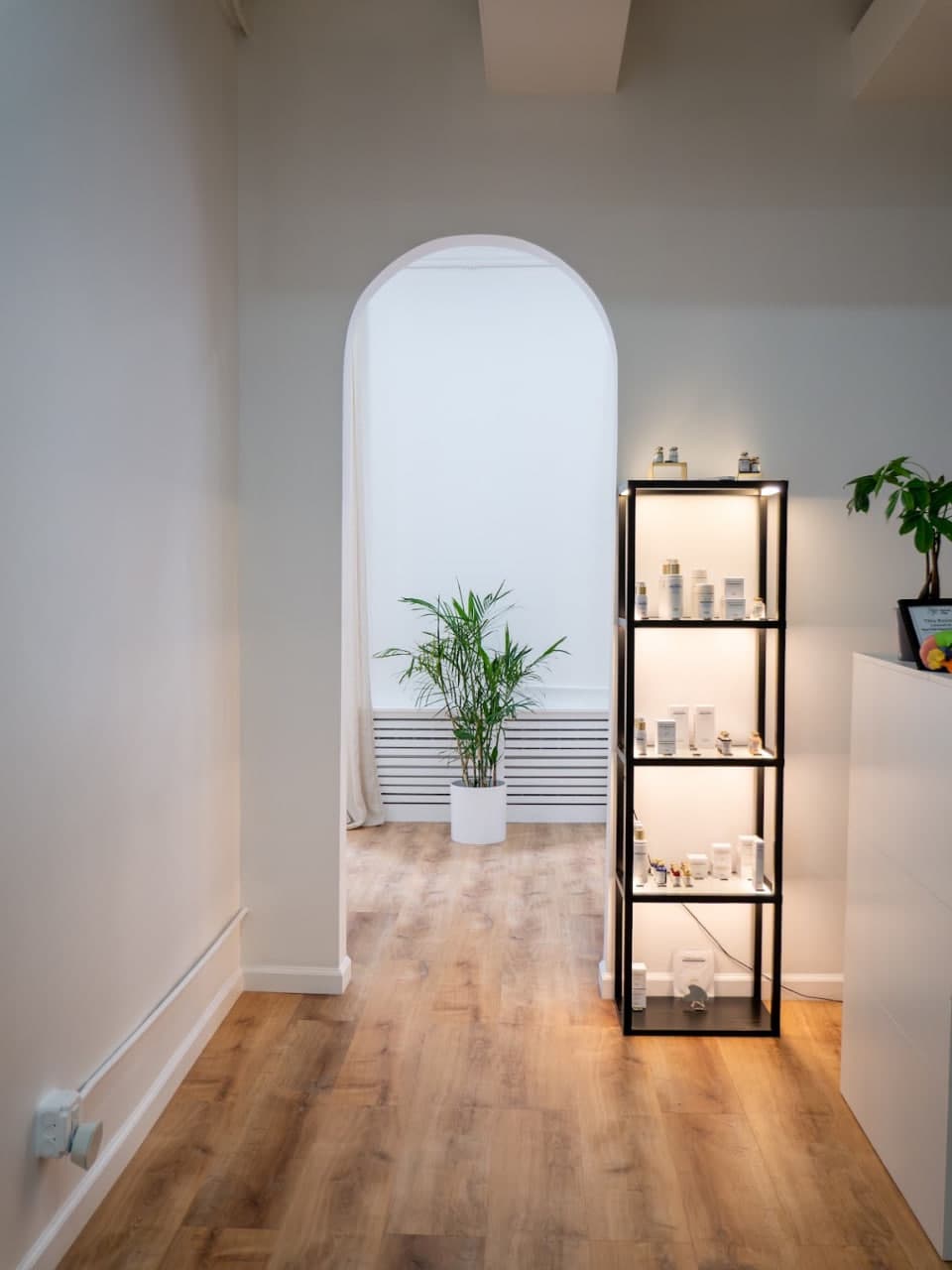 The arched hallway and skincare shelf at the studio